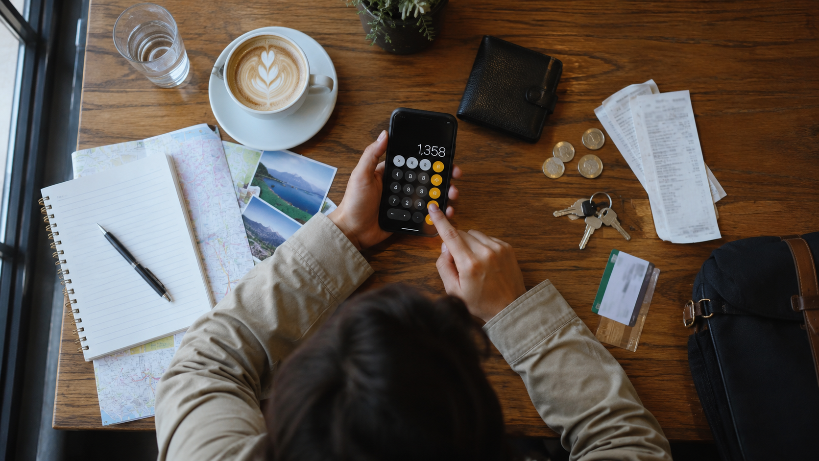 A travel budget worksheet with a calculator, wallet, and trip-planning essentials.