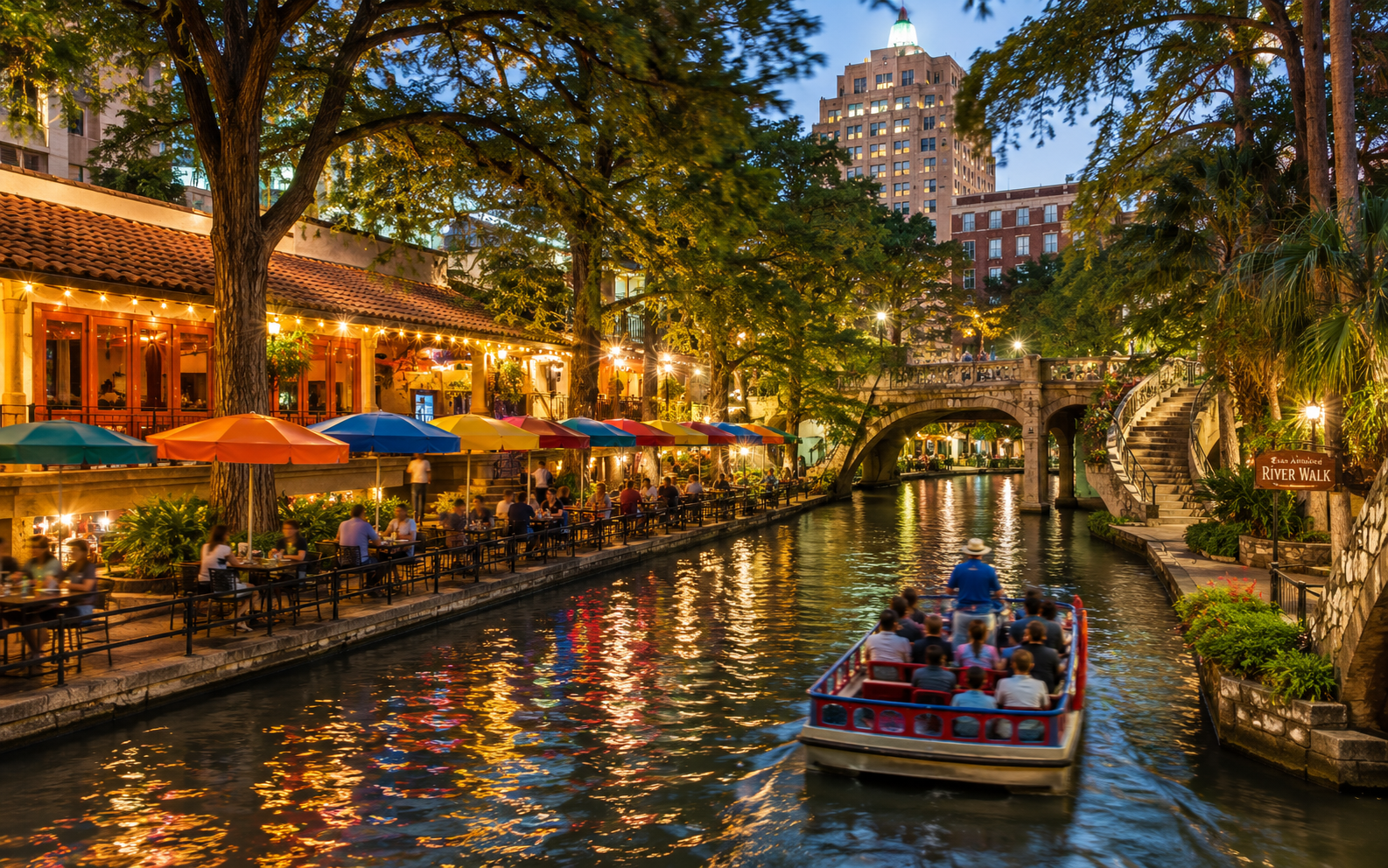 San Antonio River Walk restaurants and a tour boat glowing at dusk